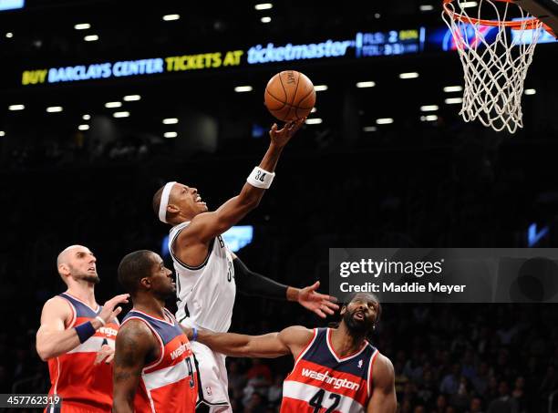 Paul Pierce of the Brooklyn Nets takes a shot over Nene of the Washington Wizards during the second half at Barclays Center on December 18, 2013 in...