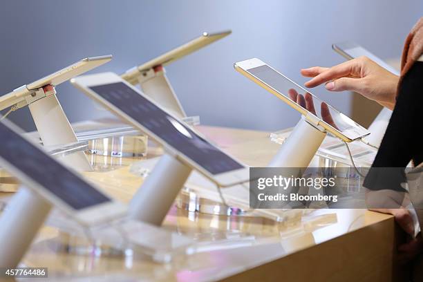 Customer tries out an Apple Inc.'s new iPad Mini 3 tablet at a SoftBank Corp. Store in the Ginza district of Tokyo, Japan, on Friday, Oct. 24, 2014....