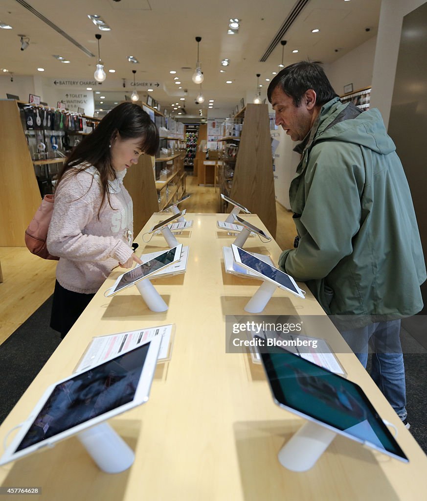 Customers look at Apple Inc.'s new iPad Air 2 and iPad Mini 3 tablets ...