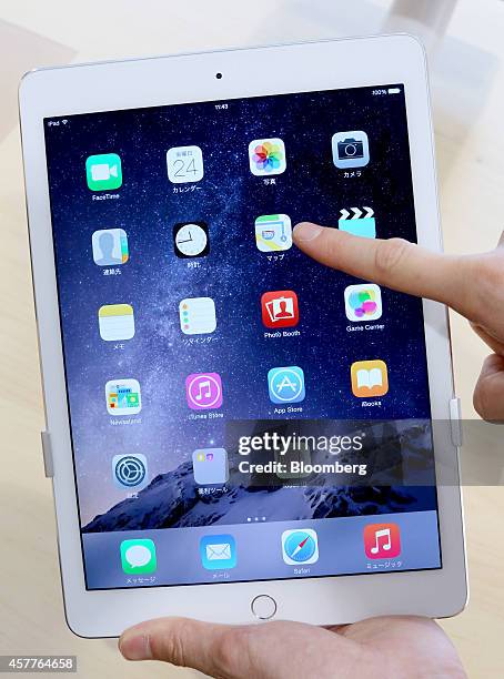 Store employee points at a 'Maps' icon on an Apple Inc. New iPad Air 2 tablet displayed at a SoftBank Corp. Store in the Ginza district of Tokyo,...