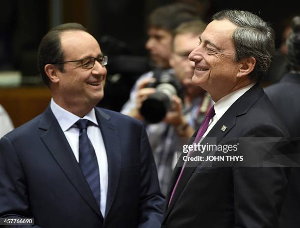 French President Francois Hollande talks with President of the European bank Mario Draghi on the second day of the European Union Summit at the EU...