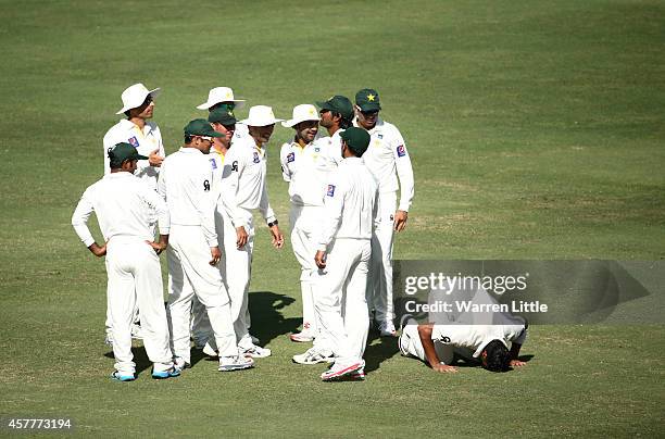 Yasir Shah of Pakistan drops to his knees to prey after dismissing Steve Smith of Australia during day three of the First Test between Pakistan and...
