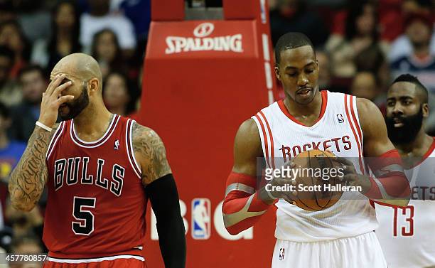 Dwight Howard and James Harden of the Houston Rockets wait under the basket alongside Carlos Boozer of the Chicago Bulls during the game at Toyota...