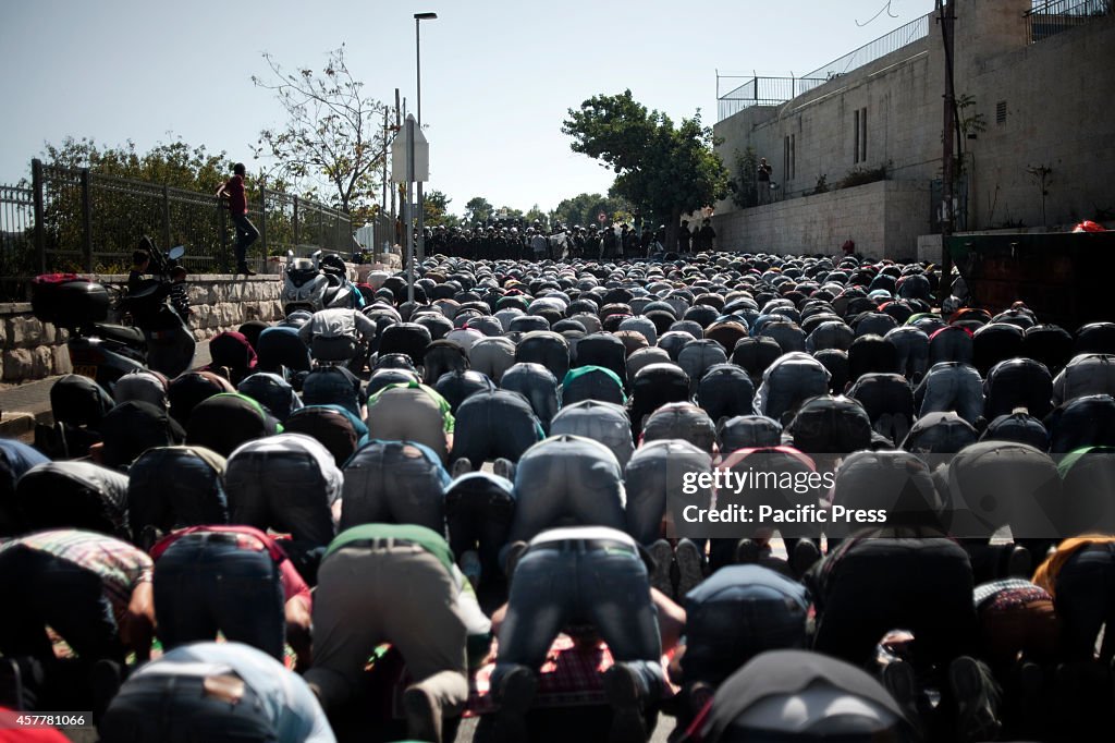 Palestinians pray outside the old city of Jerusalem after...