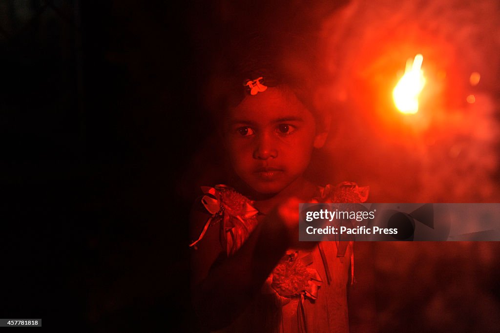 Child prays to  Goddess Kali with fire. "Kali Puja" is a...