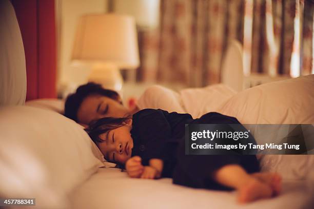 toddler girl sleeping soundly on the bed with mom - sleeping toddler bed fotografías e imágenes de stock