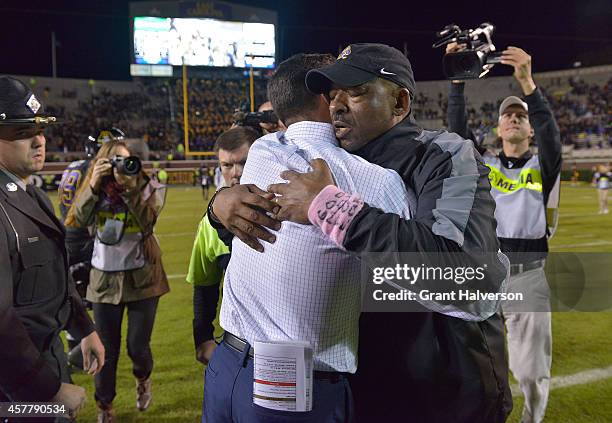 Head coach Ruffin McNeill of the East Carolina Pirates, right, embraces head coach Bob Diaco of the Connecticut Huskies after their game at...