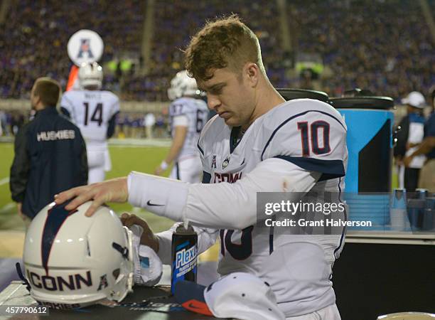 Quarterback Chandler Whitmer of the Connecticut Huskies cleans his hemet visor during their game against the East Carolina Pirates at Dowdy-Ficklen...