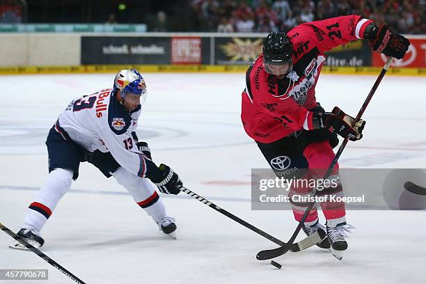 Michael Wolf of EHC REd Bull Muenchen uses his stick against John Tripp of Koelner Haie during the DEL Ice Hockey match between Koelner Haie and EHC...