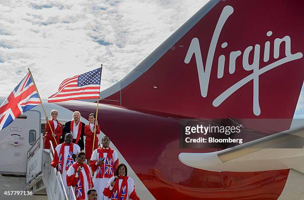 Richard Branson, chairman and founder of Virgin Group Ltd., center, exits a Boeing Co. 787 Dreamliner with Virgin Atlantic Airways Ltd. Flight...