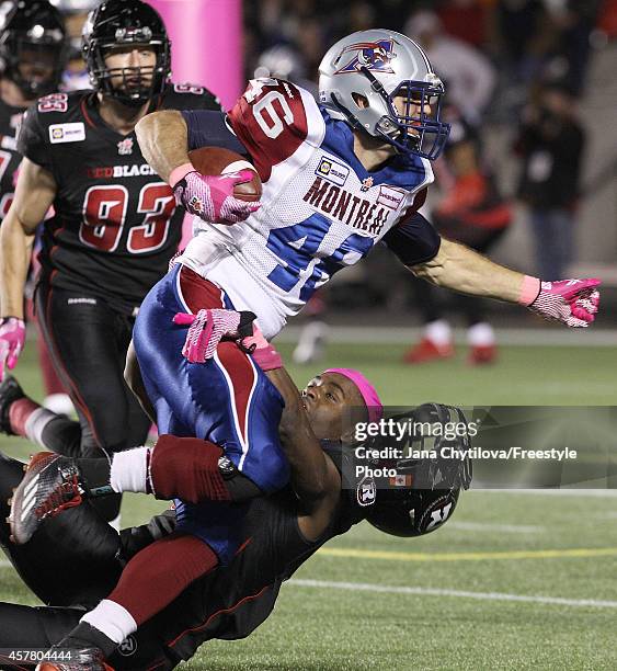 Linebacker Jasper Simmons of the Ottawa Redblacks loses his helmet as he tackles running back Jean-Christophe Beaulieu the Montreal Alouettes during...