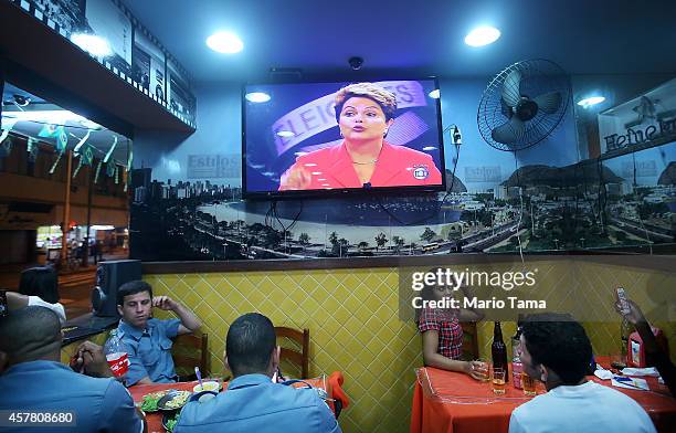 Cafe patrons listen to the broadcast of Brazilian President and Workers' Party candidate Dilma Rousseff debating with Presidential candidate of the...