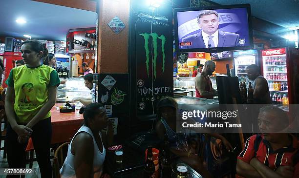 Cafe patrons listen to the broadcast of Presidential candidate of the Brazilian Social Democratic Party Aecio Neves debating Brazilian President and...