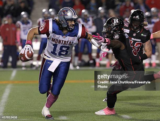 Quarterback Jonathan Crompton the Montreal Alouettes avoids a tackle by linebacker Jasper Simmons of the Ottawa Redblacks in the first quarter during...