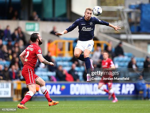 Lee Martin of Millwall jumps to head a ball under pressure from John Brayford of Cardiff during the Sky Bet Championship match between Millwall and...