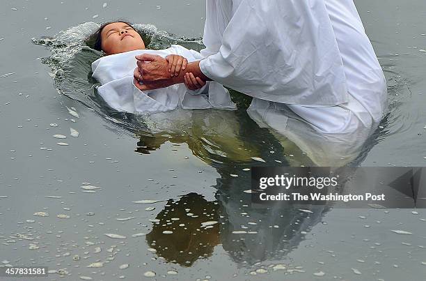 Sidney Hocutt is baptized by her grandfather, Tom Hocutt as members of Richmond's First Baptist Church take part in a baptism in the James River on...