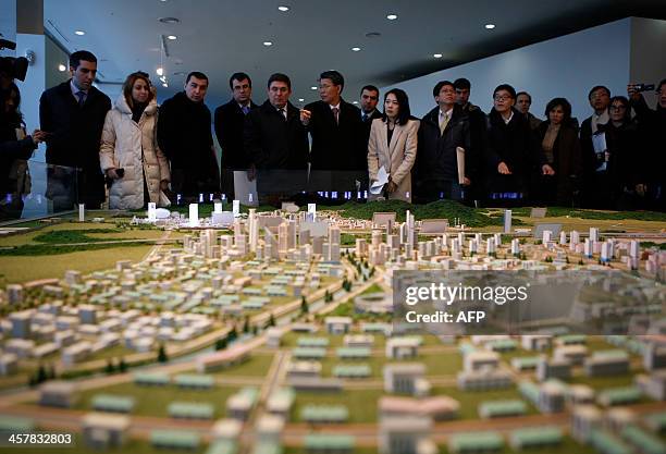 The G20 Seoul Conference delegation look at a miniature model of the Kaesong Industrial Complex at the Kaesong Industrial District Management...