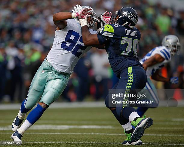 Defensive end Jeremy Mincey of the Dallas Cowboys battles tackle Russell Okung of the Seattle Seahawks at CenturyLink Field on October 12, 2014 in...