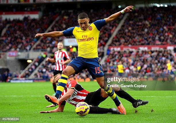 Alex Oxlade-Chamberlain of Arsenal holds off the challenge from Lee Cattermole of Sunderland during the Barclays Premier League match between...