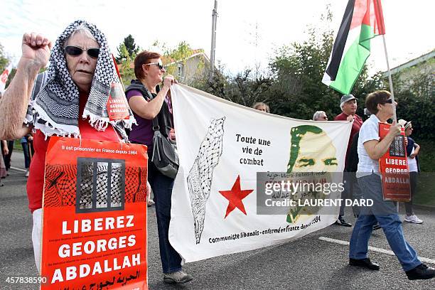 Demonstrator holds up her fist and a poster reading "Free Georges Abdallah", as around 300 people gather to call for the release of "Lebanese...