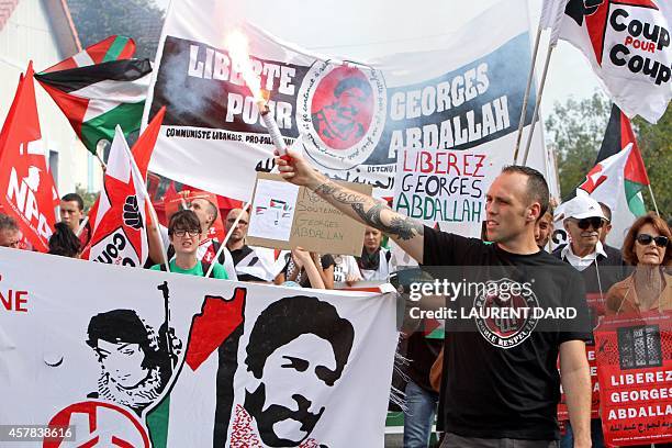 Demonstrator holds up a flare near a banner reading "Freedom for Georges Abdallah", as around 300 people gather to call for the release of "Lebanese...