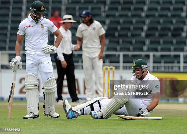 South African batsman Graeme Smith sits on the field after falling down next to his teammate Alviro Petersen on the second day of the first cricket...