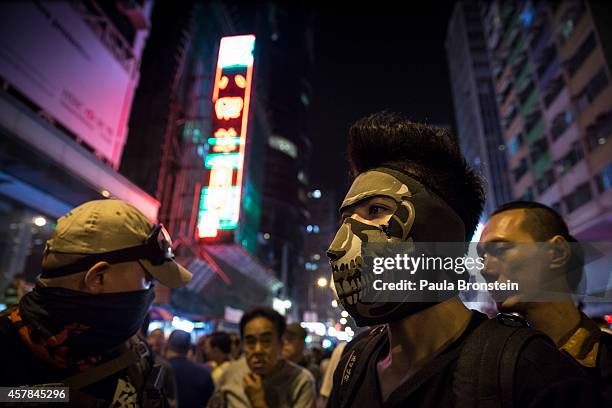 Masked protesters stand at the barriers dividing the police from the crowds in Mongkok October 25, 2014 in Hong Kong, Hong Kong. While the main...