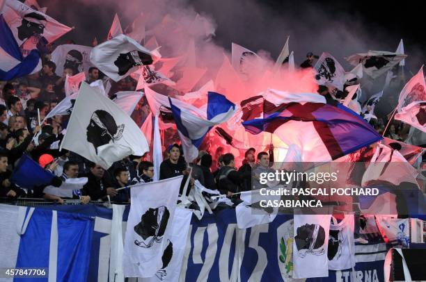Bastia's supporters cheer for their team with Corsican flags and flares during the French L1 football match between Bastia and Monaco in Bastia,...