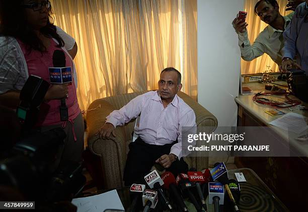 Uttam Khobragade , the father of Indian diplomat Devyani Khobragade gestures as he addresses media representatives during a news conference in Mumbai...