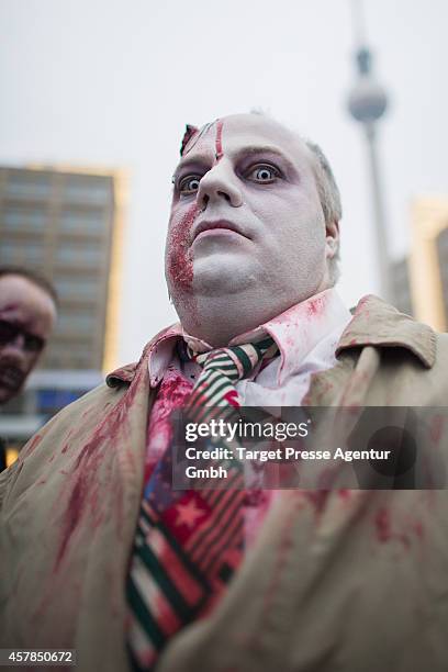 Zombie enthusiast walks over the Alexanderplatz as part of a flashmob on October 25, 2014 in Berlin, Germany. Over 150 participants dressed as...