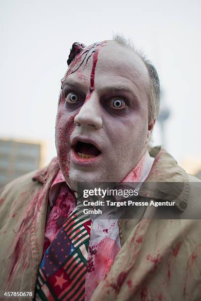 Zombie enthusiast walks over the Alexanderplatz as part of a flashmob on October 25, 2014 in Berlin, Germany. Over 150 participants dressed as...