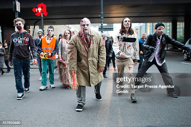 Zombie enthusiasts walk over the Alexanderplatz as part of a flashmob on October 25, 2014 in Berlin, Germany. Over 150 participants dressed as...