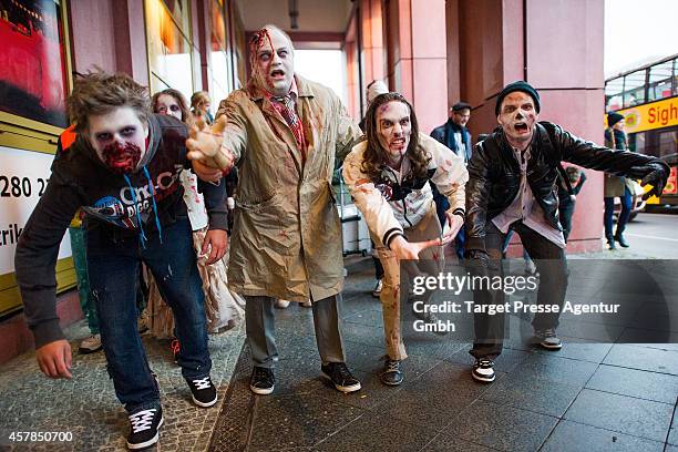 Four zombie enthusiasts walk over the Alexanderplatz as part of a flashmob on October 25, 2014 in Berlin, Germany. Over 150 participants dressed as...