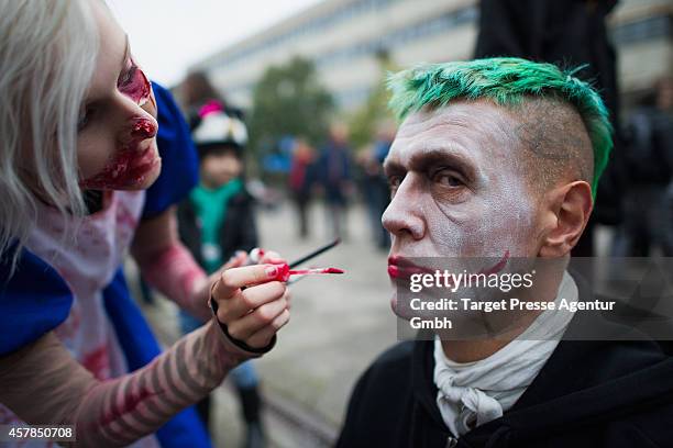 Zombie enthusiast is getting a fresh make up as part of a flashmob on October 25, 2014 in Berlin, Germany. Over 150 participants dressed as zombies...