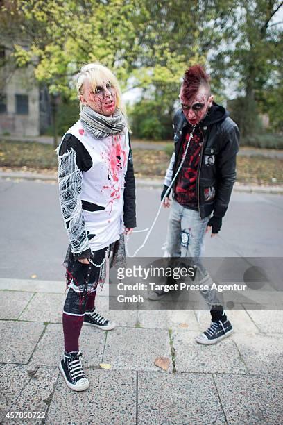 Two zombie enthusiast walk over the Alexanderplatz as part of a flashmob on October 25, 2014 in Berlin, Germany. Over 150 participants dressed as...