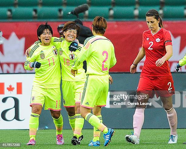 Shinobu Ohno, Saori Airyoshi, and Yukari Kinga of Japan celebrate after their teammate Aya Miyama scored against Canada during a match at...