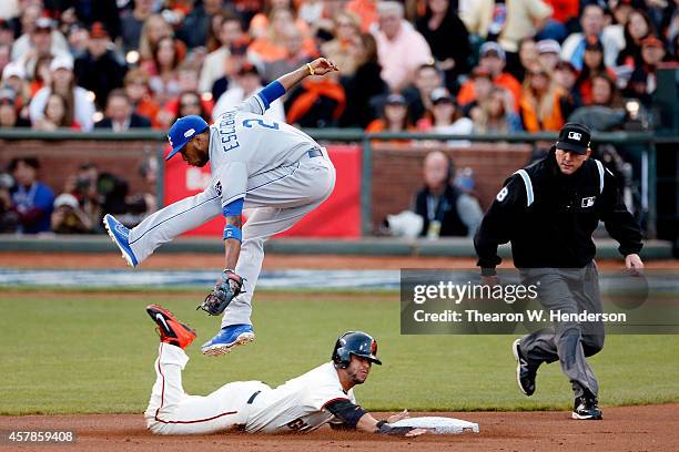 Alcides Escobar of the Kansas City Royals leaps to catch a ball as Gregor Blanco of the San Francisco Giants advances on a wild pitch in the first...