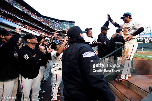 Gregor Blanco of the San Francisco Giants celebrates with teammates after scoring in the first inning against the Kansas City Royals during Game Four...