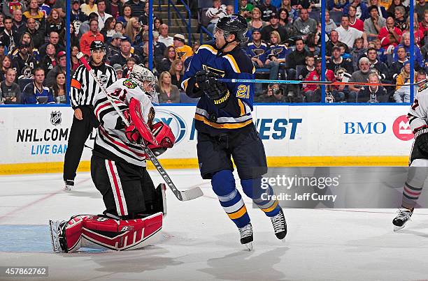 Patrik Berglund of the St. Louis Blues is hit by a puck as Antti Raanta of the Chicago Blackhawks defends the net on October 25, 2014 at Scottrade...