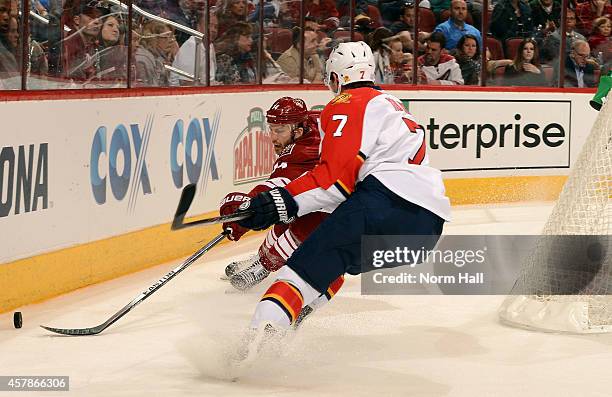 Center Joe Vitale of the Arizona Coyotes pushes the puck past defenseman Dmitry Kulikov of the Florida Panthers during the second period of the NHL...