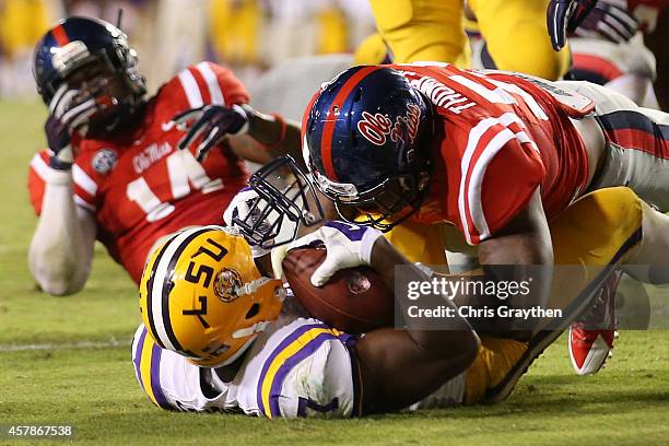 Leonard Fournette of the LSU Tigers has his face mask pulled off by Serderius Bryant of the Mississippi Rebels at Tiger Stadium on October 25, 2014...