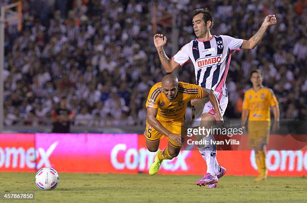 Cesar Delgado of Monterrey passes the ball over the mark of Egidio Arevalo of Tigres during a match between Monterrey and Tigres UANL as part of 14th...