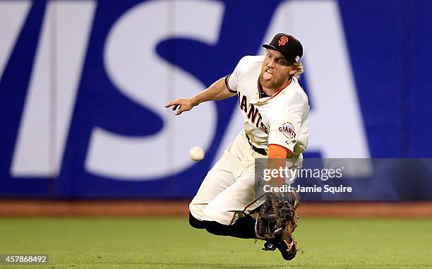 Hunter Pence of the San Francisco Giants makes a diving catch on a ball hit by Lorenzo Cain of the Kansas City Royals in the ninth inning during Game...