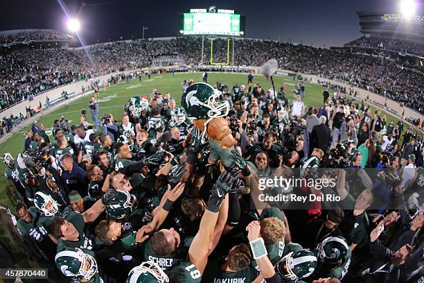 Michigan State Spartans lift the Paul Bunyan trophy after the game against the Michigan Wolverines at Spartan Stadium on October 25 , 2014 in East...