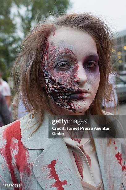 Zombie enthusiast walks over the Alexanderplatz as part of a flashmob on October 25, 2014 in Berlin, Germany. Over 150 participants dressed as...