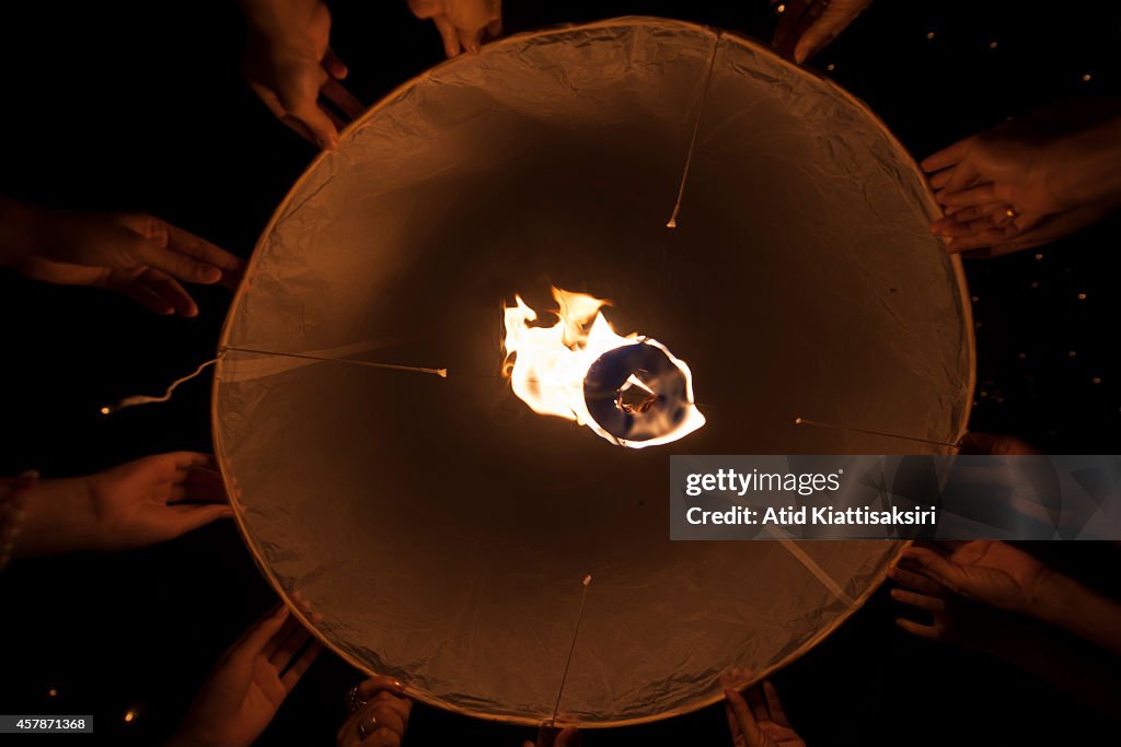 Human hands hold a Khom Loi(sky lantern) during the...
