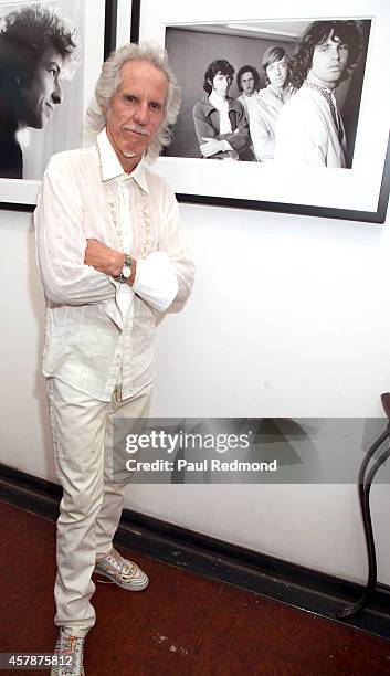 Musician John Densmore of The Doors poses next to a photograph of himself at "Big Shots: Rock Legends & Hollywood Icons" Guy Webster book release &...