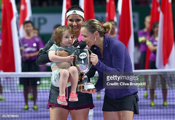 Cara Black of Zimbabwe and her son Lachlan along with her partner Sania Mirza of India hold the Martina Navratilova Trophy after their straight sets...