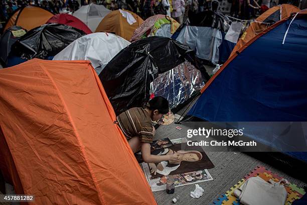 Pro-democracy activist works on a painting amongst tents on a street outside Hong Kong's Government Complex in on October 26, 2014 in Admiralty...