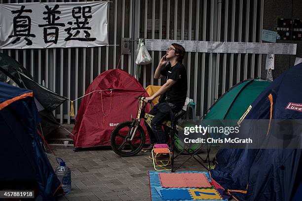 Pro-democracy activist speaks on the phone amongst tents on a street outside Hong Kong's Government Complex in on October 26, 2014 in Admiralty...